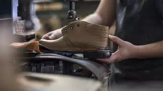 Szewc w trakcie produkcji brązowych butów ze skóry.