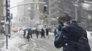 Ludzie spacerują po mieście podczas śnieżycy