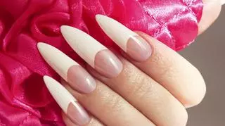 Kobieca dłoń z bardzo długimi paznokciami pomalowanymi w stylu french manicure. Modny manicure. Trendy.