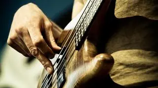 osoba, która gra na gitarze basowej 