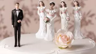 Tort ślubny ozdobiony pięcioma marcepanowymi figurkami.