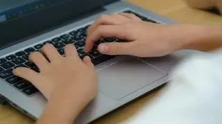 Dziecko piszące na klawiaturze laptopa