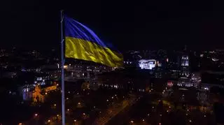 Ukraińska flaga na tle miasta. Pomoc Ukrainie. 