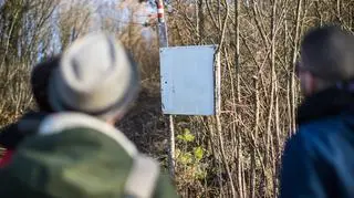 Dwie osoby patrzące na oznakowanie szlaku