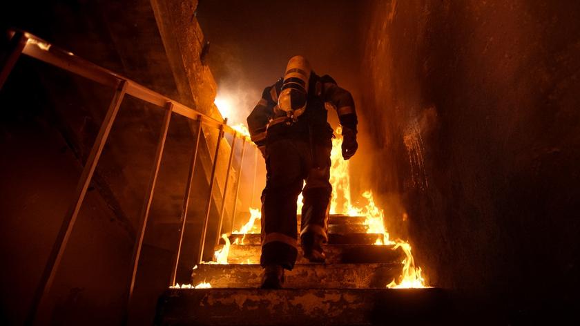Strażak na schodach płonącego domu