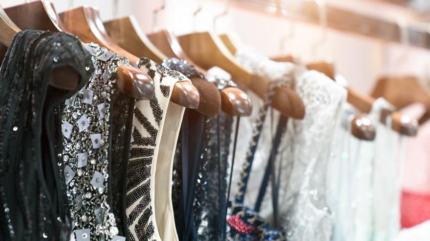 Eleganckie sukienki wiszą na wieszakach. 