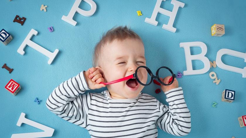 Dziecko na tel rozrzuconych literek i klocków