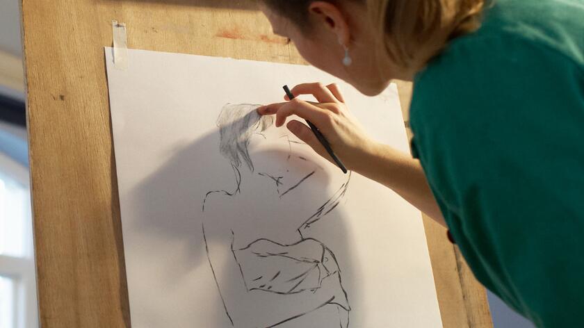 koieta przy sztalugach szkicuje kobieca postac