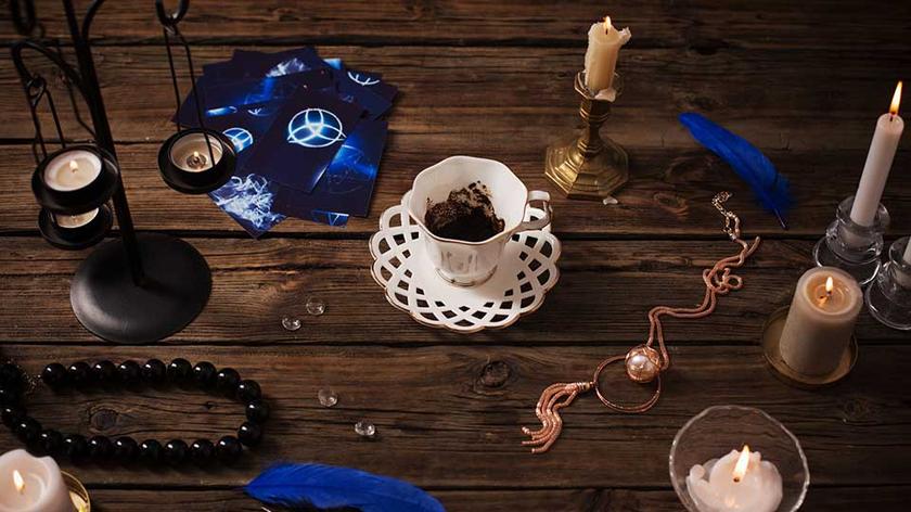 Filiżanka z fusami, karty, świeca