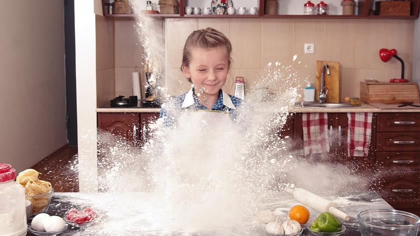 Dziewczynka bawi sie mąką