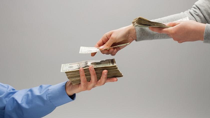 jedna osoba przekazuje drugiej dużo pieniędzy z ręki do ręki