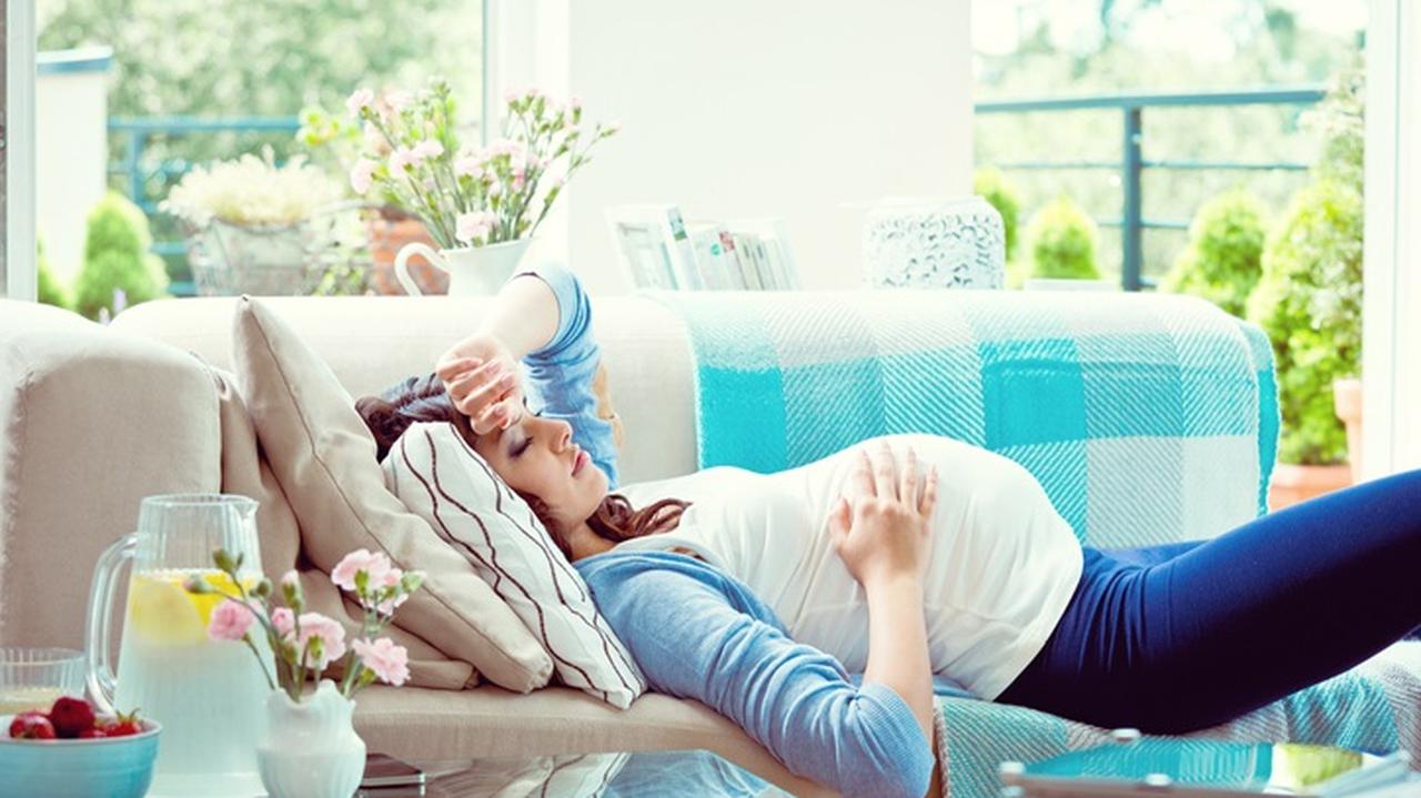 Kobieta w ciąży leży na sofie 