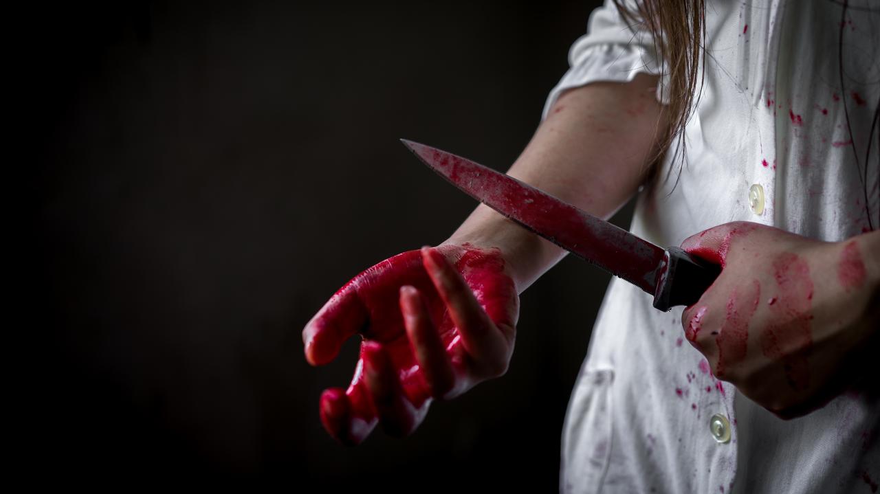 Damska dłoń we krwi, w drugim ręku nóż przykładany do nadgarstka
