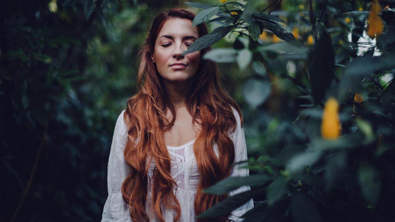 Medytacja, kobieta z rudymi, długimi włosami w lesie