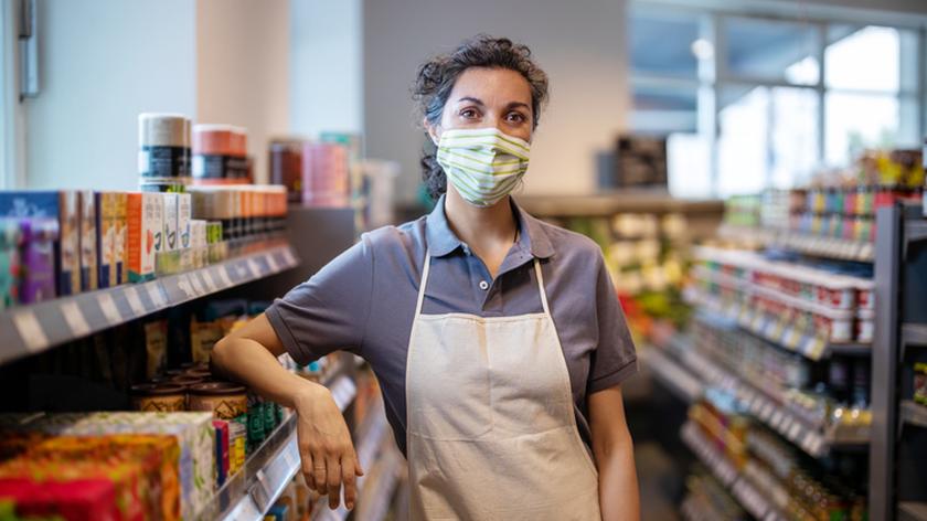 Sprzedawczyni w sklepie spożywczym w maseczce