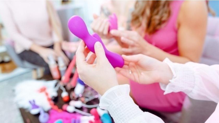 Kobiece dłonie trzymające fioletową zabawkę erotyczną