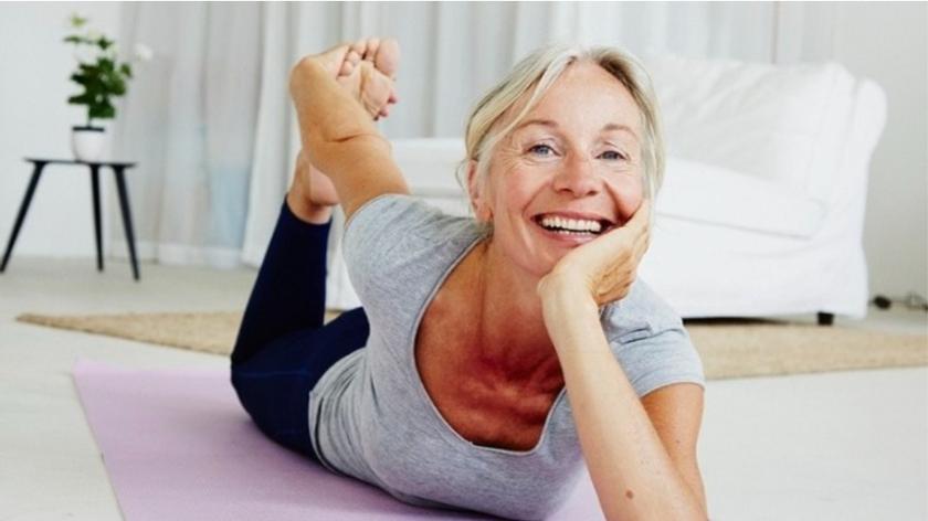 Uśmiechnięta kobieta ćwicząca jogę na macie