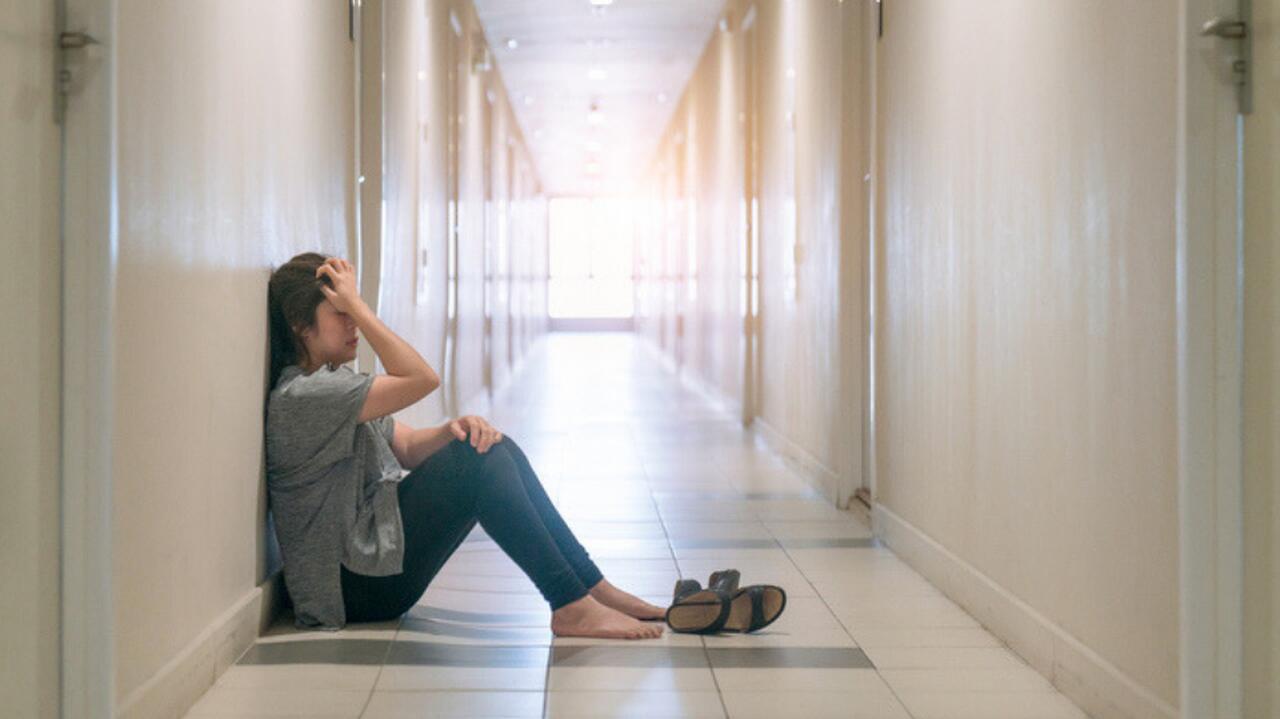kobieta z depresja siedzaca w korytarzu placze