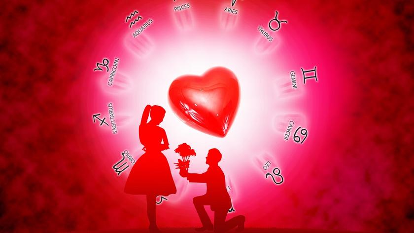 Grafika prezentująca znaki zodiaku wokół serca a pod nim klęczy mężczyzna oświadczający się kobiecie
