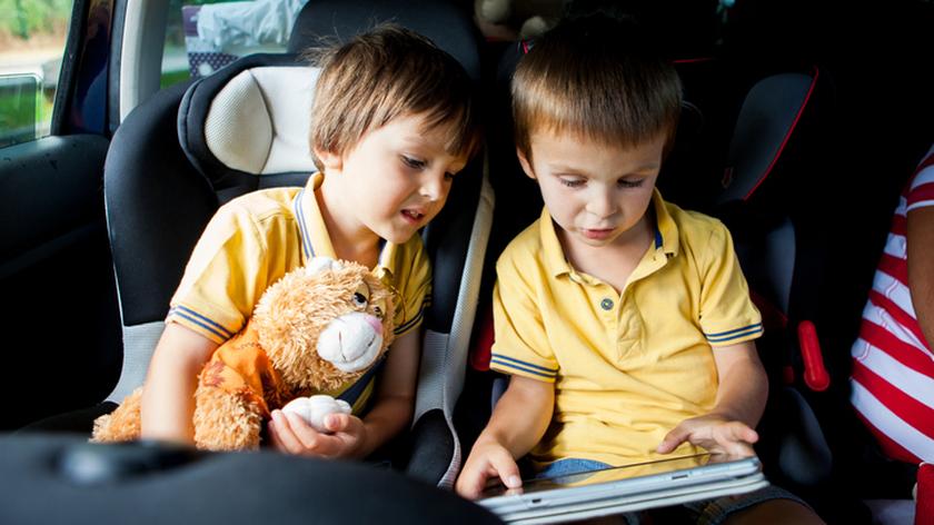 Dzieci siedzą w fotelikach 