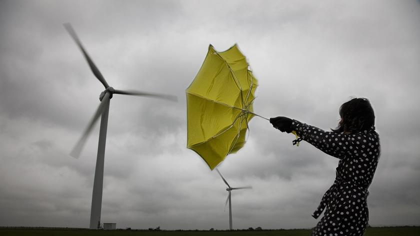 Kobieta z wygiętym od wiatru parasolem 