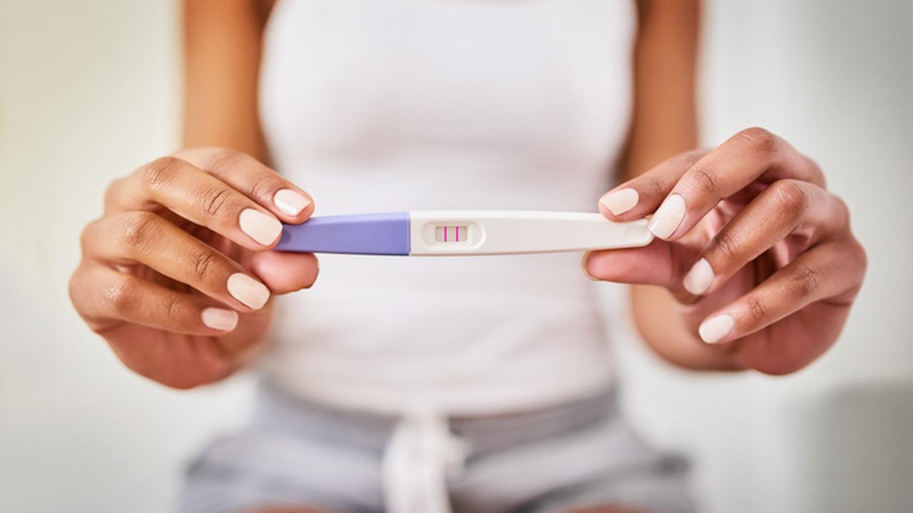 Kobieta trzyma test ciążowy z pozytywnym wynikiem