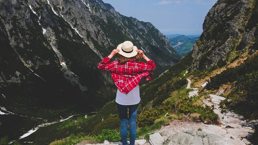 kobieta w kapeluszu stojąca tyłem i patrząca na Tatry