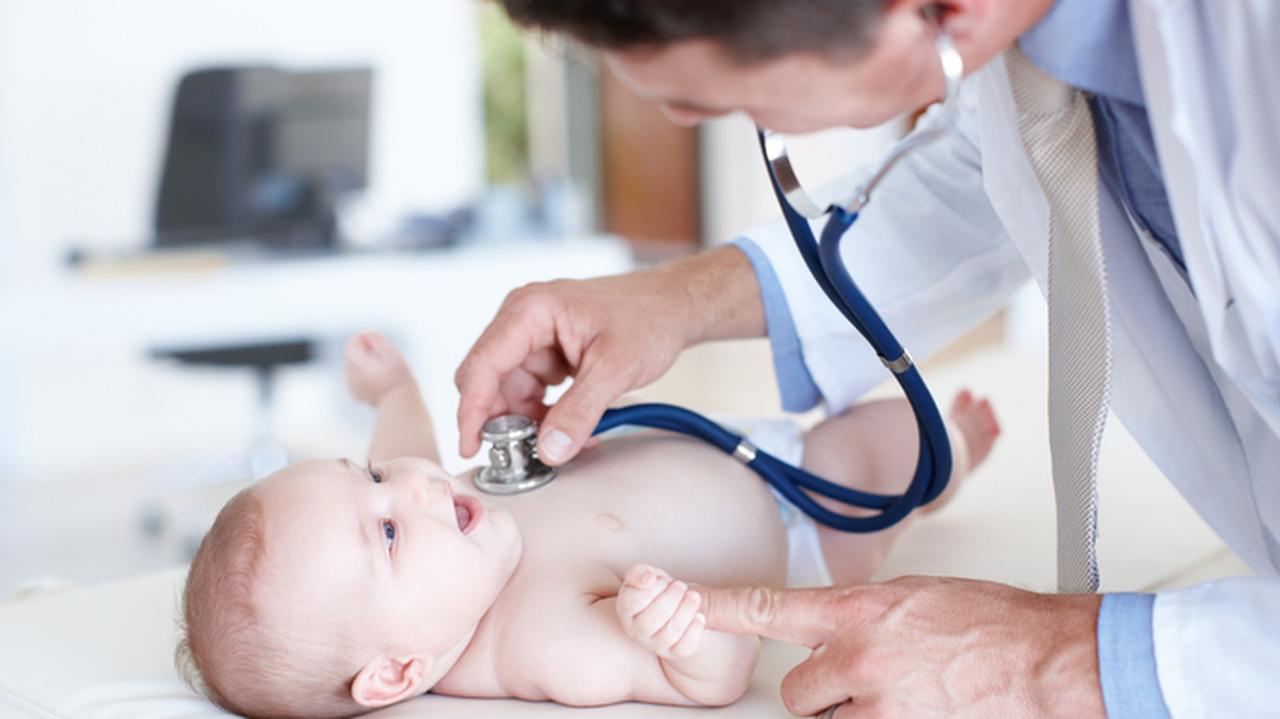 Młody lekarz bada niemowlaka