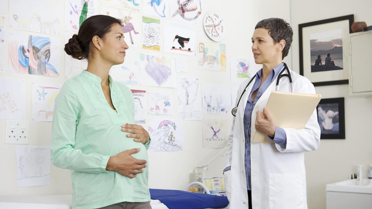 Kobieta w ciąży słucha lekarza