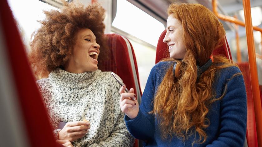 Dwie roześmiane kobiety z gęstymi włosami