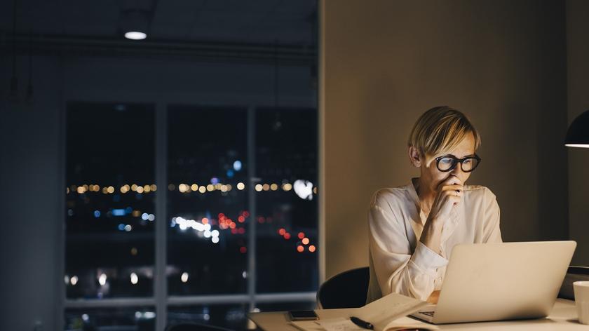 kobieta pracująca przy komputerze, wieczór za oknem