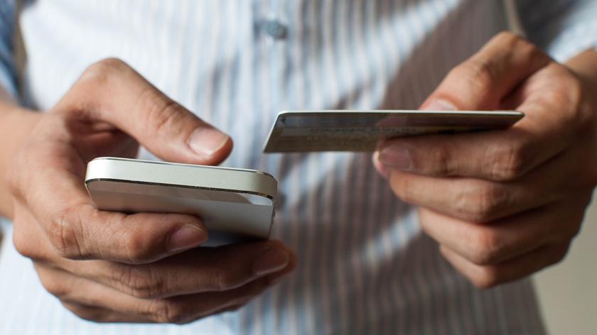 telefon i karta bankowa w dłoniach
