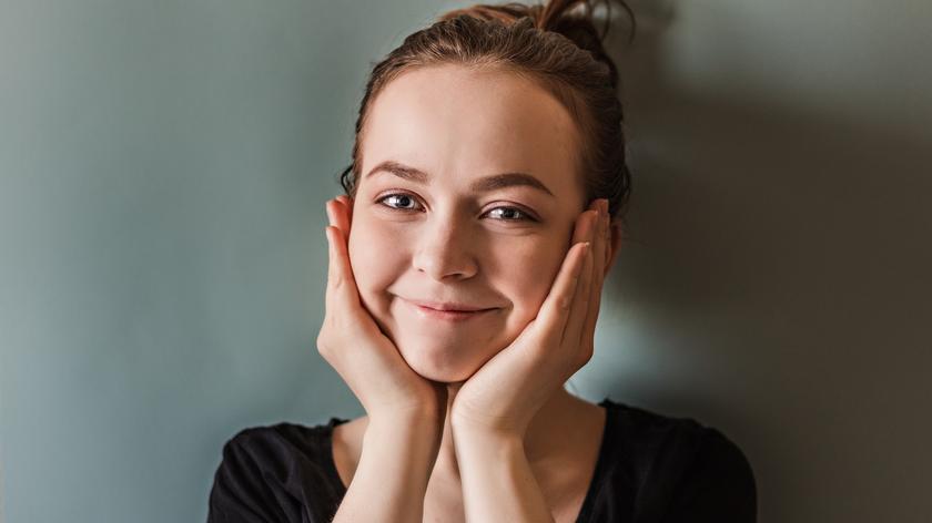 Kobieta trzymająca się za podbródek