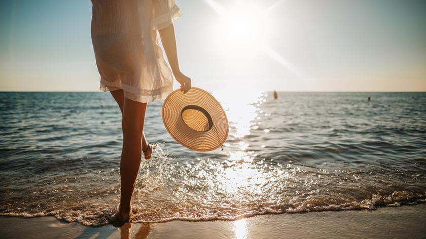 Kobieta w białej sukience na plaży