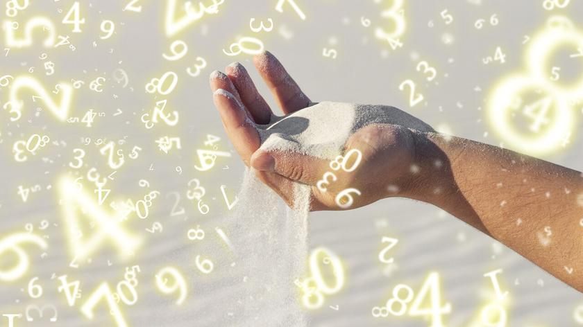 Numerologiczna ilustracja z przesypującym się piaskiem przez dłonie
