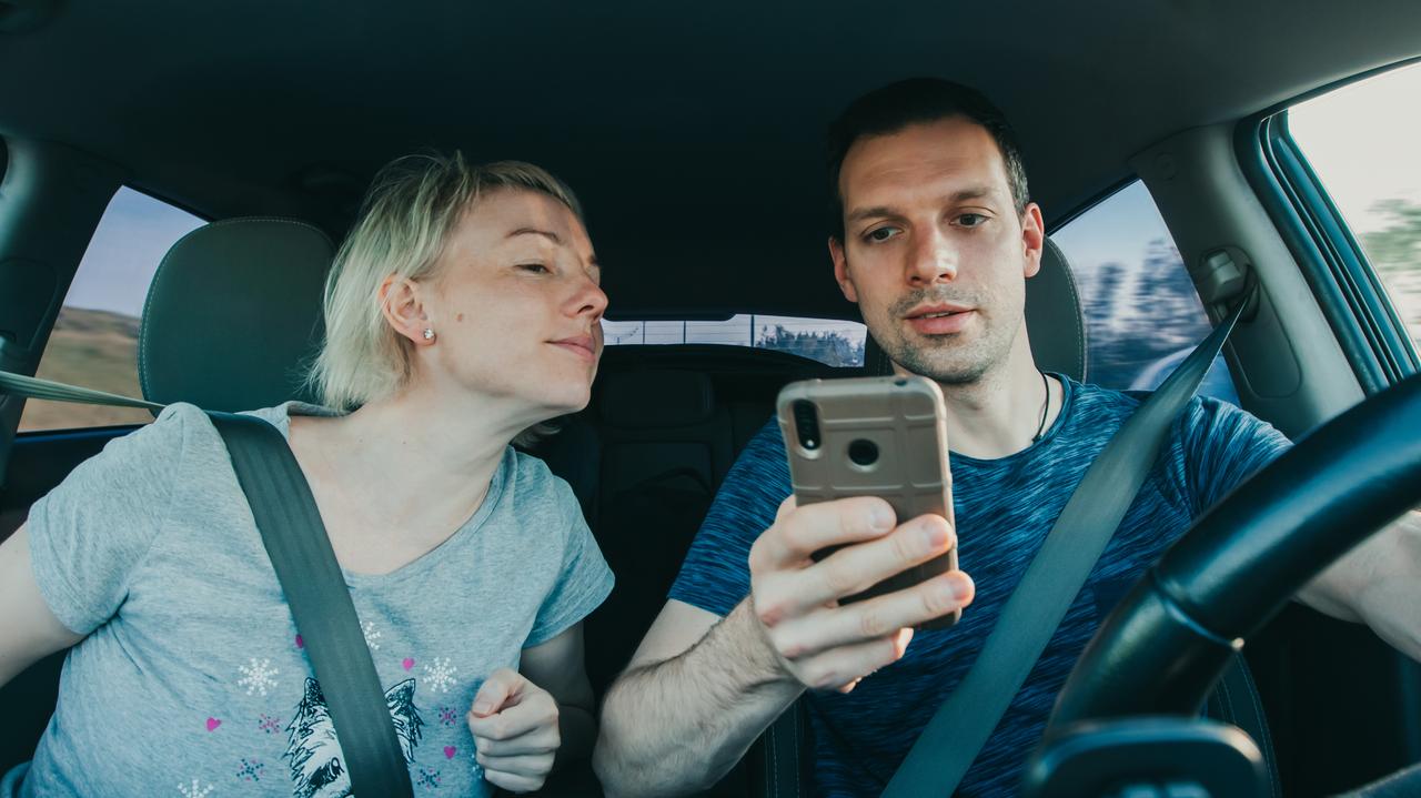 Mężczyzna i kobieta w samochodzie, korzystają z telefonu