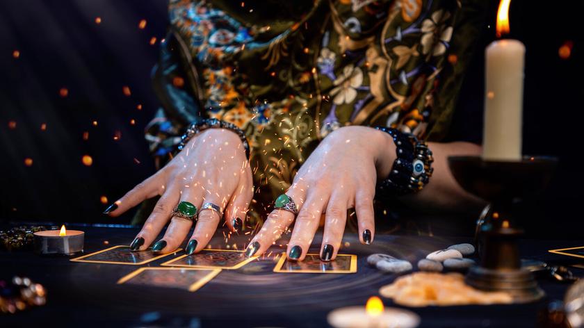 Kobiece dłonie nad kartami tarota