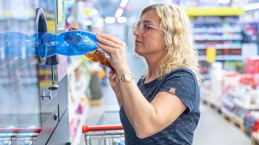 Kobieta zwracająca plastikowe butelki do automatu