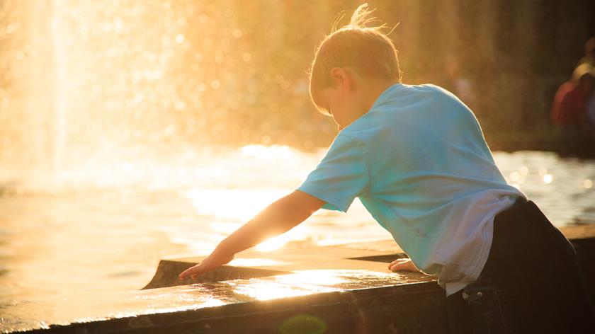 Dziecko wypoczywające przy fontannie