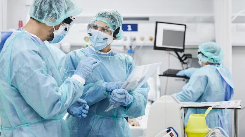 Lekarze w maseczkach i kombinezonach ochronnych