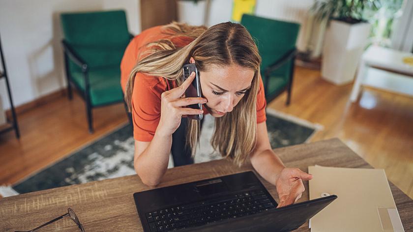 Kobieta zmartwiona stojąca nad laptopem