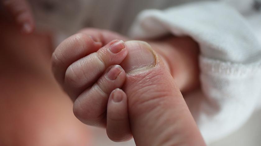 Noworodek trzyma palec mamy