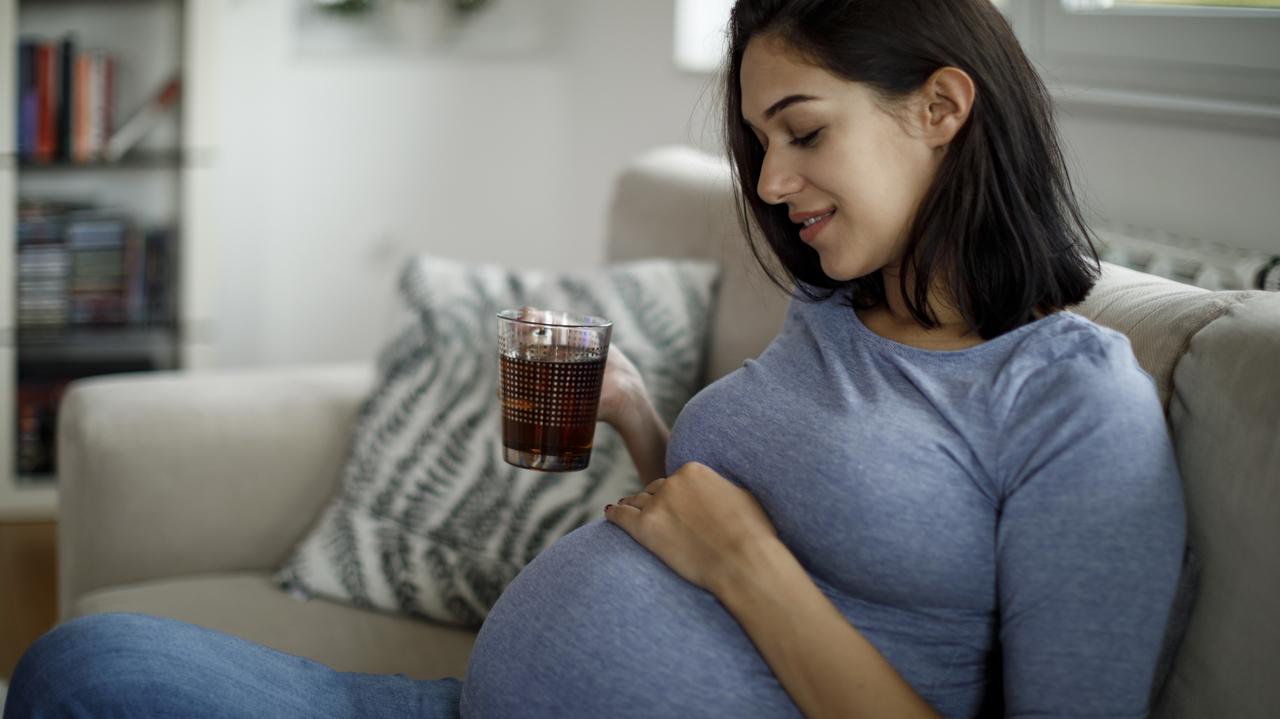 Kobieta w ciąży z kubkiem napoju
