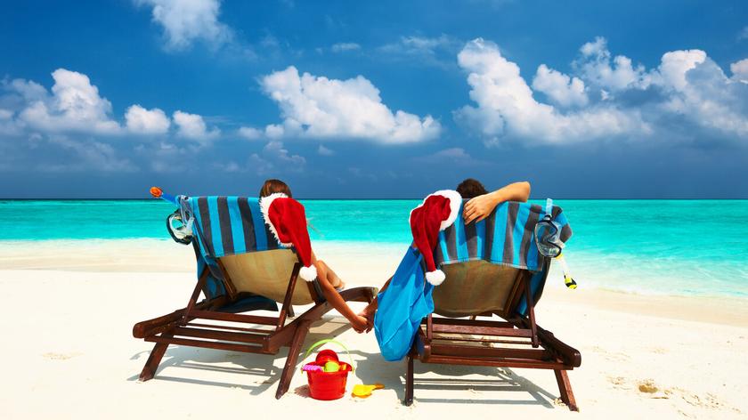 Para na plaży z mikołajowymi czapkami