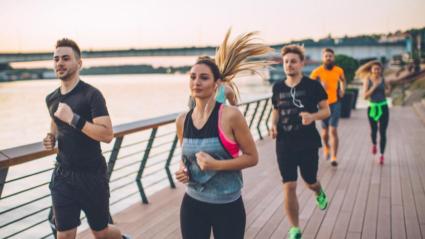 Biegacze na kładce w mieście