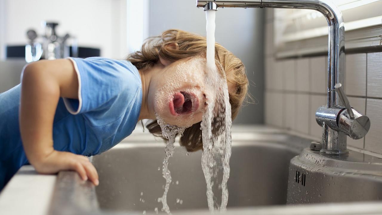 dziecko, które pije wodę z kranu 