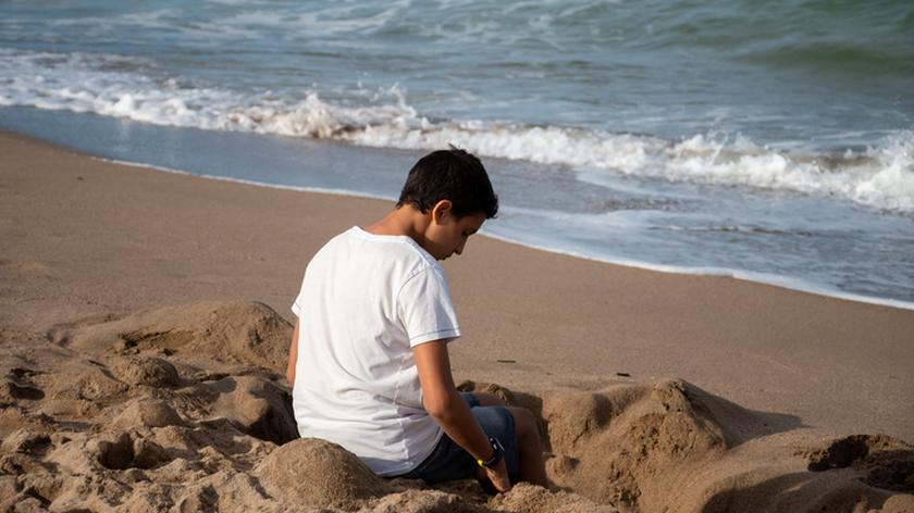 nastolatek kopie dół na plaży