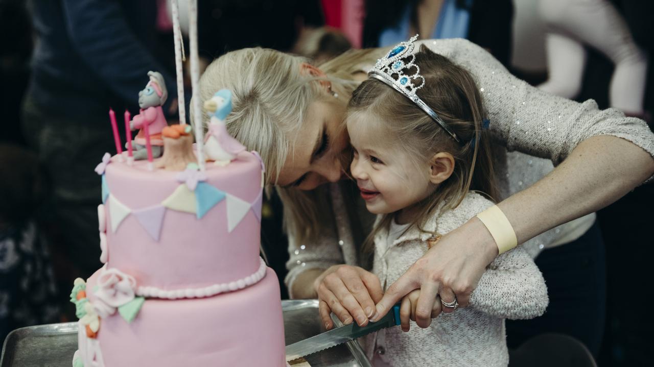 Dziewczynka kroi tort urodzinowy