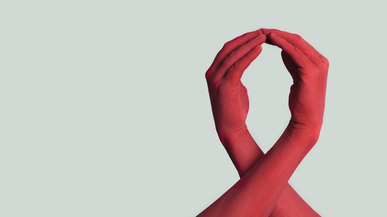 dłonie splecione w czerwoną kokardkę - symbol aids