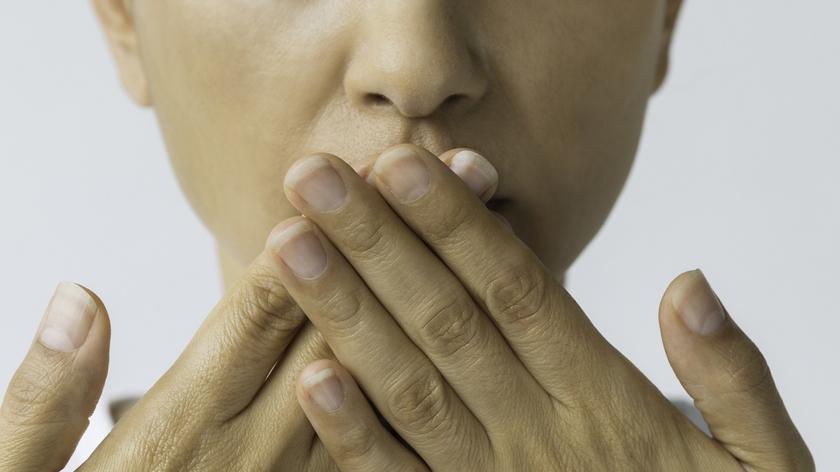 osoba, która wącha swoją dłonie 